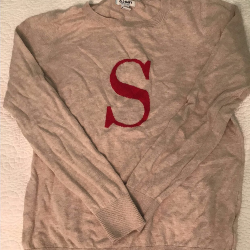 Beige cardigan with red S in the center